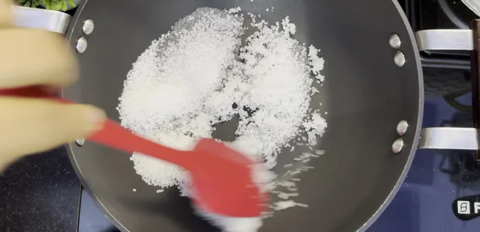 Once the sugar starts melting, stir it gently with a spatula. Reduce heat to low to prevent burning.
