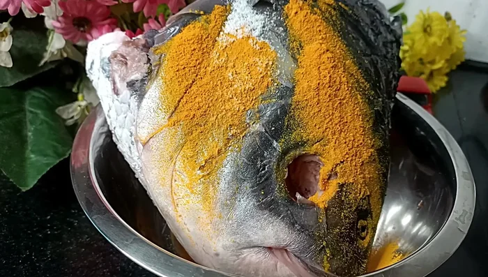 Remove the fish eyes and wash the fish head thoroughly. Add turmeric powder and salt, mixing well to remove the fishy smell. (167.28)