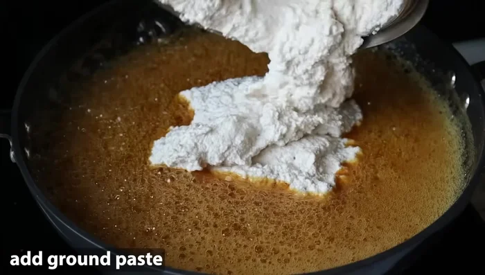 Add the peanut paste to the boiling jaggery mixture. Mix well to ensure there are no lumps.