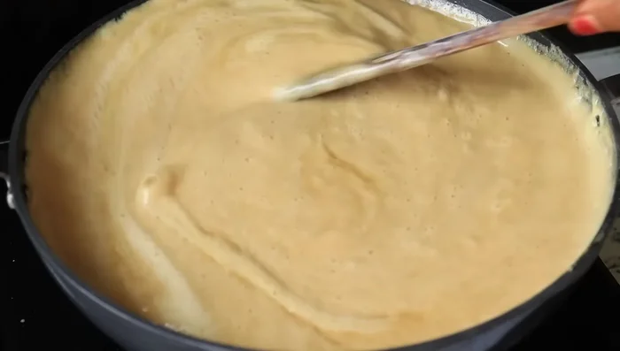 Continue to mix vigorously over high heat until the mixture thickens to a halwa-like consistency. You may need to adjust the heat to low to avoid burning. Add ghee gradually (1/4 cup total) while mixing.