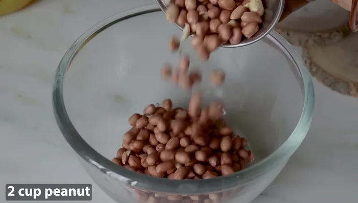 Take 2 cups of raw, unroasted peanuts. Wash them thoroughly to remove any dirt or dust.