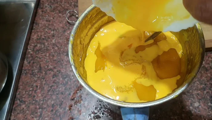 Add the custard mixture to the mango-sugar mixture and mix well. You can use a mixer or whisk.