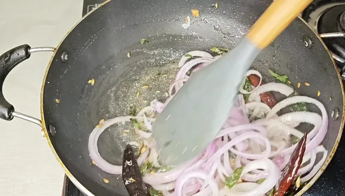 Add the sliced onions and green chilies. Sauté until slightly softened but still crunchy. Add salt, red chili powder, garam masala, and chaat masala (and turmeric if using). Mix well.