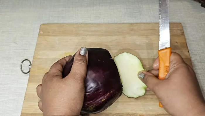 Cut the brinjals into large pieces (avoid those with many seeds). Deep fry them until golden brown on both sides. This ensures they are soft and cook well.