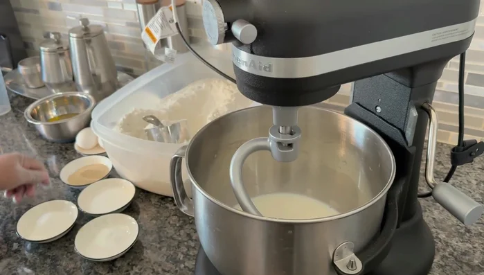 Gradually add flour to the mixture, mixing on low speed. Add more flour if needed to achieve a dough-like consistency. Add milk if it's too thick.