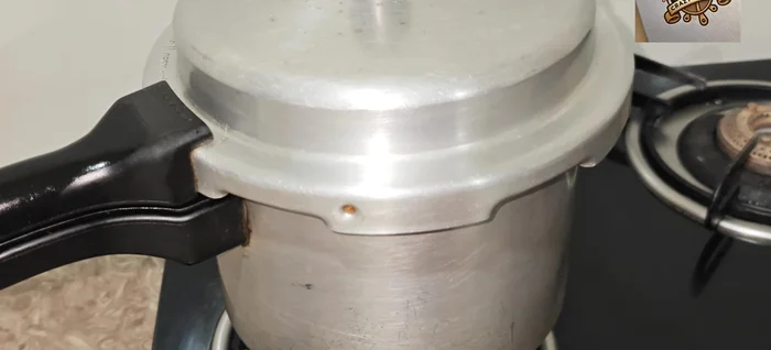 Dry the chicken: Once the cooker has whistled twice, open the lid, drain excess water, and place the cooker back on the gas stove on high flame to completely dry the remaining moisture.