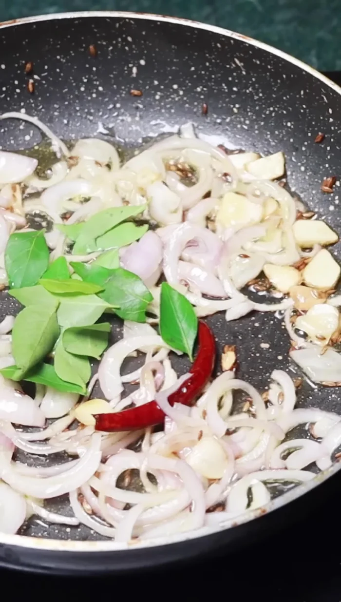 Add curry leaves and green chilies; fry briefly. Add Kashmiri chili powder, then remove from heat.