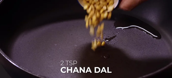 Roast dal and spices: In a heavy bottom pan, heat oil. Add chana dal, urad dal, fenugreek seeds, coriander seeds, mustard seeds, and cumin seeds. Roast on medium flame until golden brown and fragrant.