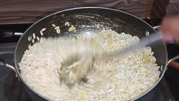 Add puffed rice and fry until slightly crunchy.