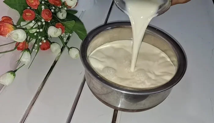 In a pot, combine 1 litre of filtered cow's colostrum milk and 1 cup of sugar. Stir continuously until the sugar dissolves completely.