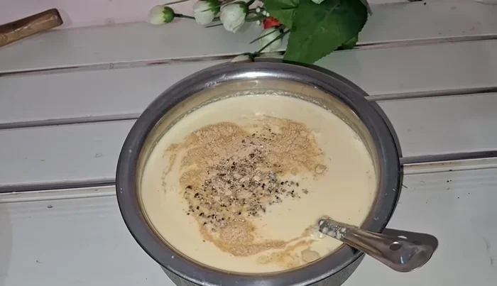 Add dry ginger powder and crushed cardamom powder to the milk mixture. Mix well to ensure no lumps remain.