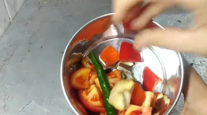 Coarsely grind tomato, ginger, and green chilli in a mixer jar.