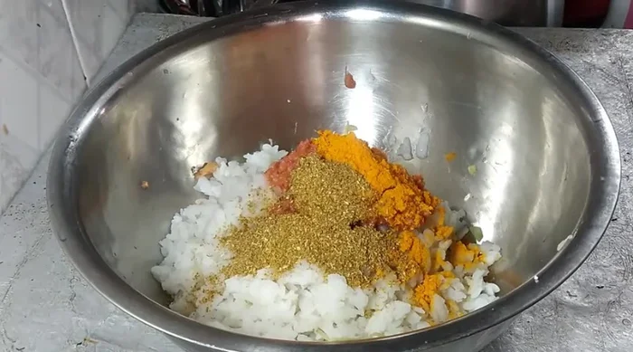 Mix poha with the ground tomato mixture, turmeric powder, coriander powder, asafoetida, cumin, and green coriander.