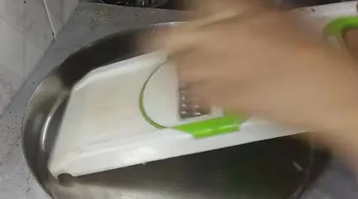 Peel and grate potato. Wash thoroughly to remove starch.