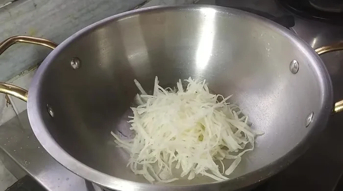 Heat oil, add cumin, grated potatoes, sliced cabbage, chopped onion, and grated carrots. Add salt and cook until slightly softened, not completely cooked.