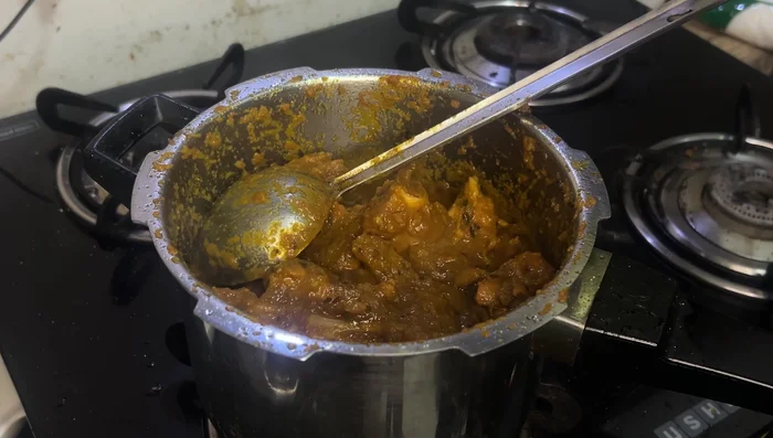 Add water, reduce heat, and cook in a pressure cooker for 3-4 whistles.