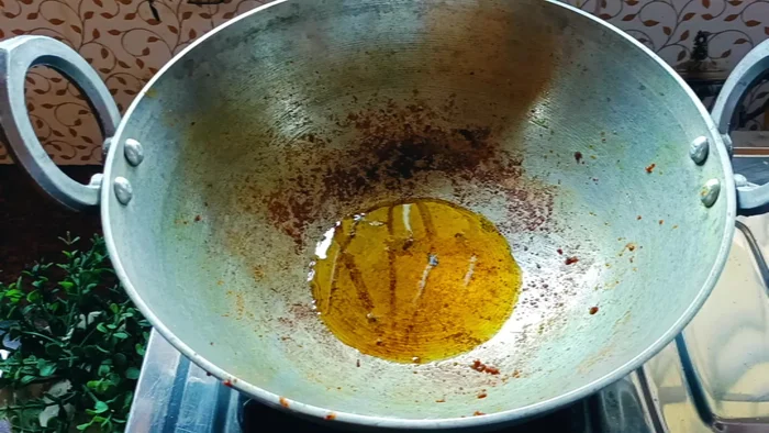 Add 2 more tablespoons of mustard oil to the same pan. Add a bay leaf and the chopped onions. Fry until brown. Add green chilies if desired.