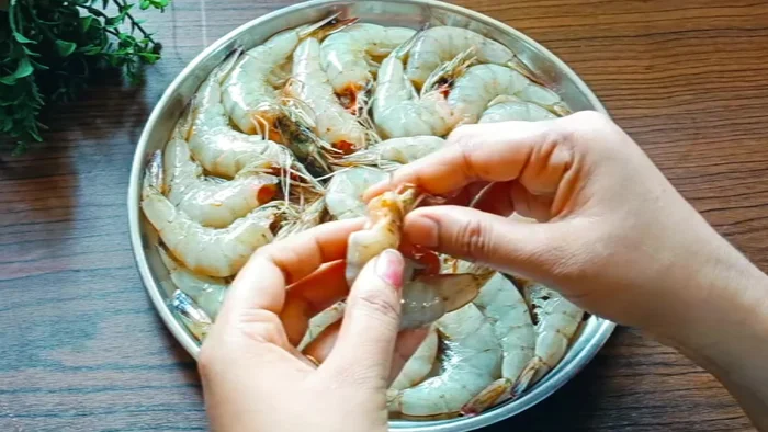 Clean the prawns by washing them thoroughly. Remove the black thread inside by cutting them in the middle and pulling it out.