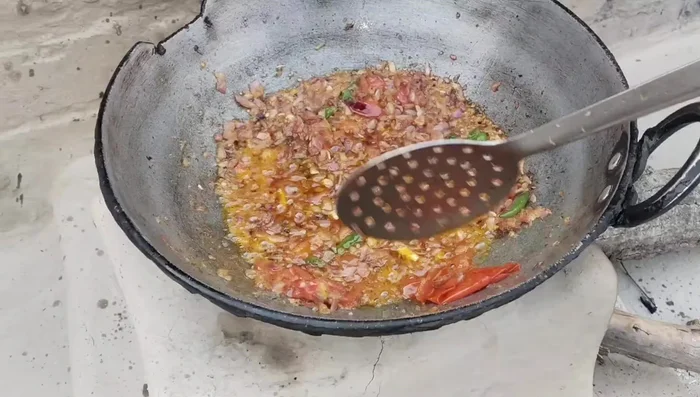 Fry the whole tomatoes until their peels come off. Remove the peels if desired.