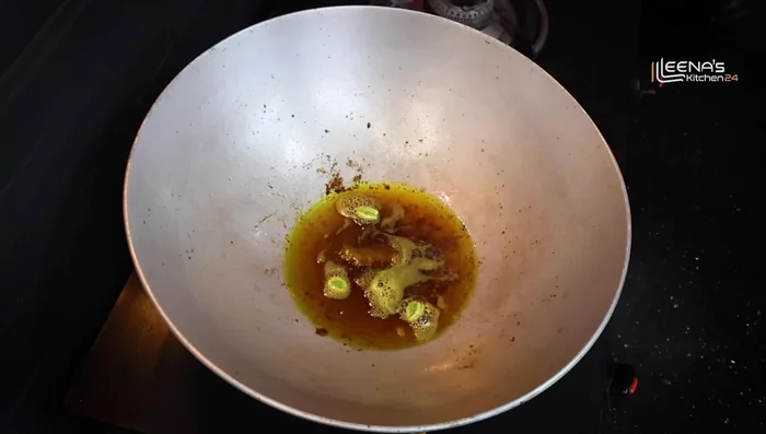 In the same pan, add 1 piece cinnamon, 2-3 green cardamoms, 1 bay leaf, 1/2 teaspoon nigella seeds, and 2-3 dried red chilies. Fry for 5-7 seconds.