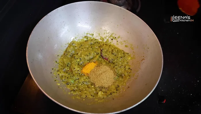 Add 1/2 teaspoon turmeric powder, 1 tablespoon coriander powder, 1 tablespoon Kashmiri red chili powder, 1/2 teaspoon degi red chili powder. Mix well and add water to create a paste.