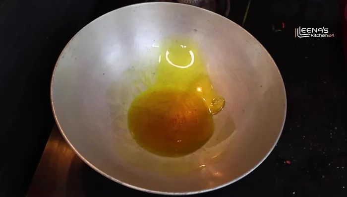 Heat a pan and add mustard oil. Add a pinch of salt to prevent splattering.
