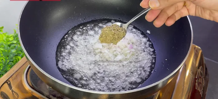 In a pan, heat 0.5 cup oil and sauté chopped onions and 1 tsp cumin seeds until softened.
