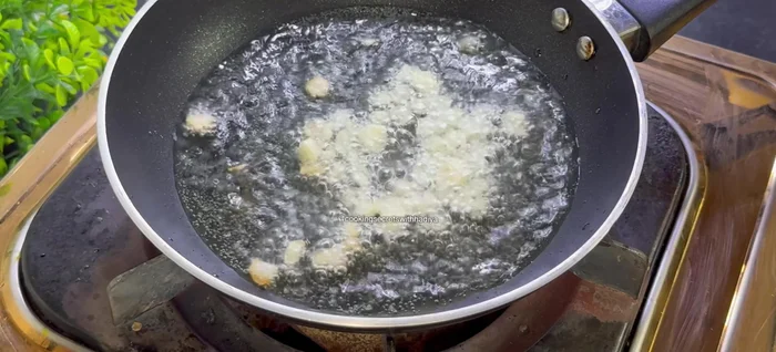 Prepare tadka: Heat 3 tbsp oil. Add garlic cloves, dried red chilies, green chilies, and cumin seeds. Fry until golden.