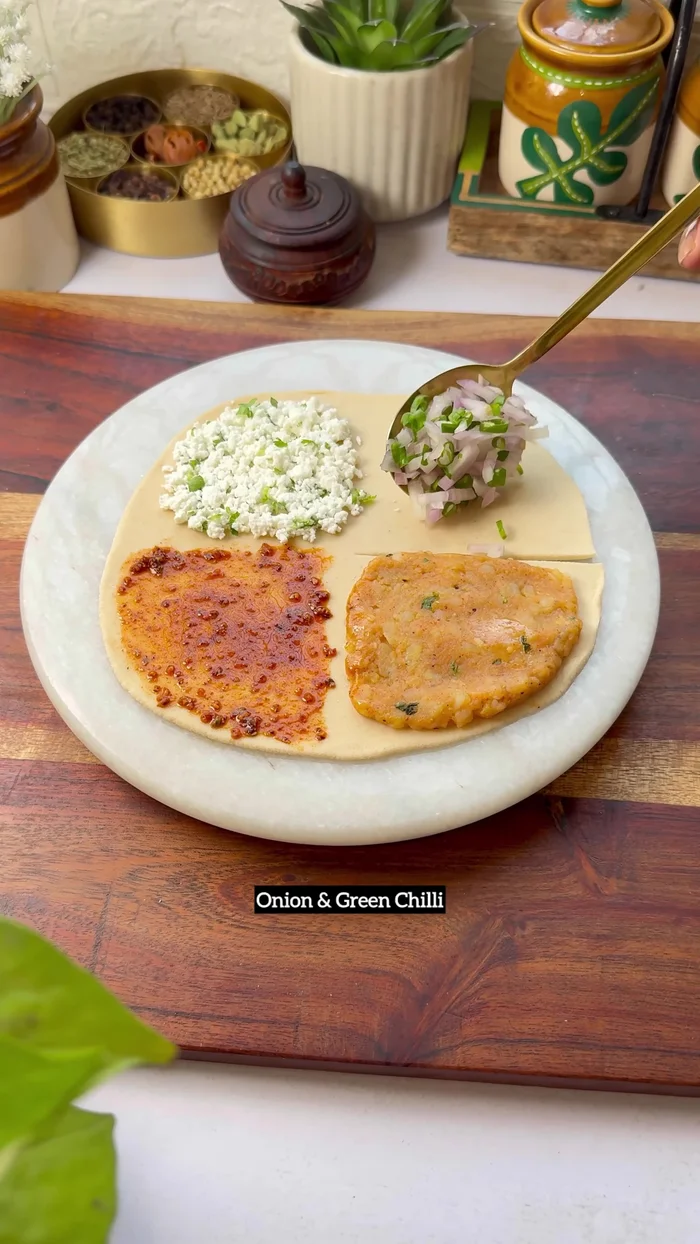 For Four-in-One Paratha: Roll out roti dough. Make cuts and fill with potato mixture, paneer mixture, and onion and green chili mixture. Fold and shape into a paratha. Cook for 5 minutes per side with ghee.