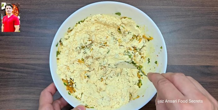Add the sifted gram flour to the vegetable mixture and mix well with your hands until a smooth paste is formed.