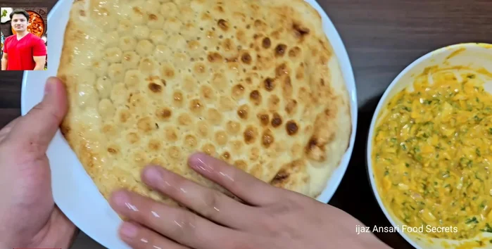 Lightly wet the naan bread with water.