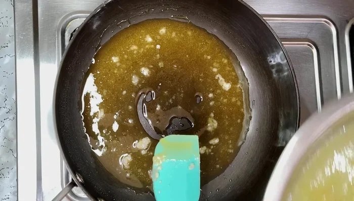 Add the mango puree to the dissolved sugar. Add black salt and optional turmeric powder.