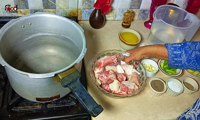 Place the goat's butt (approximately 1.25 kg, including fat) in a pressure cooker.