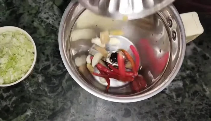 Grind sprouted gram, garlic, ginger, and red chilies coarsely in a mixer without adding water. (54.96)