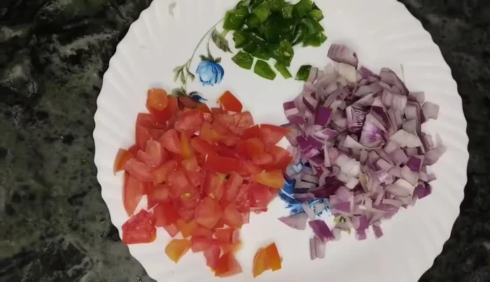 In a bowl, combine the ground mixture, grated cabbage, chopped onion, capsicum, and diced tomato (seeds removed). (87.119)