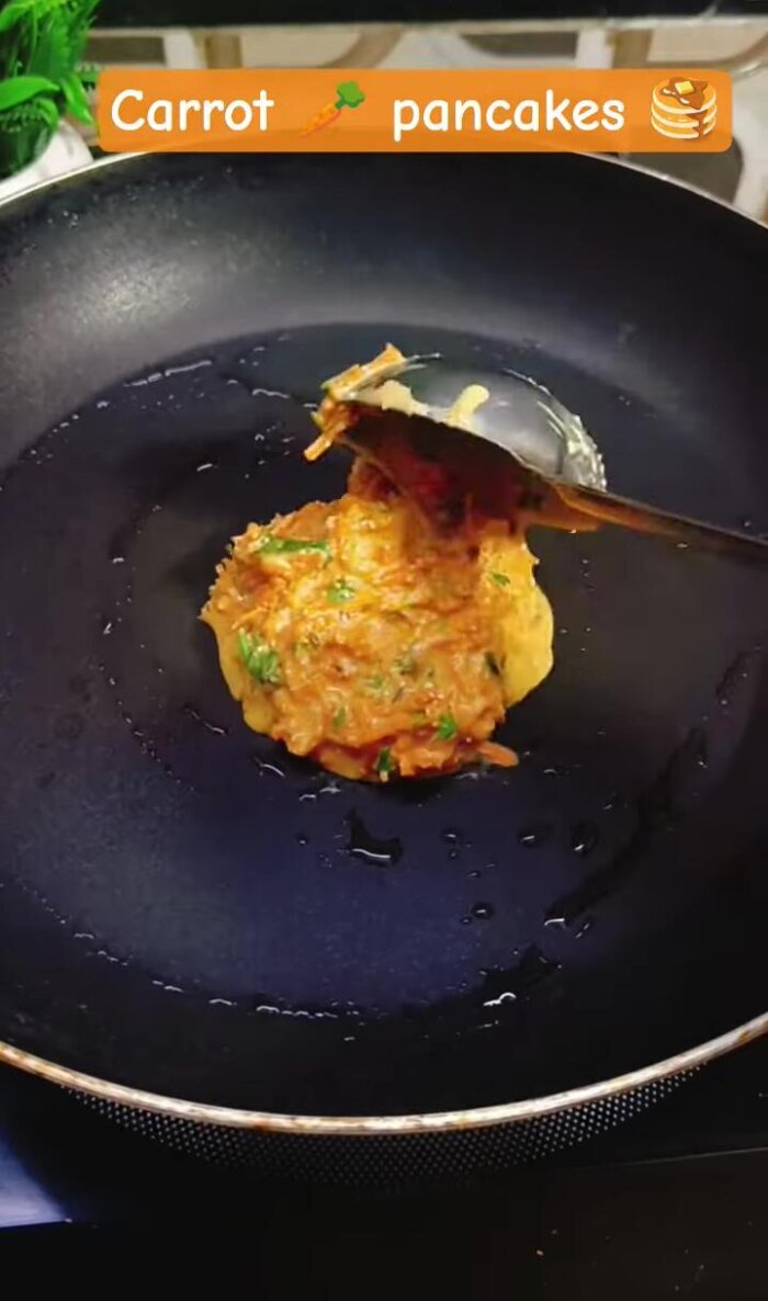 Add at least two spoons of carrot batter to the pan.