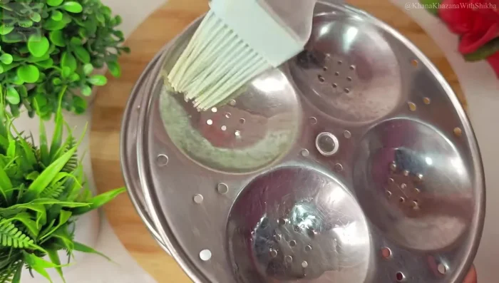 Grease an idli stand well with oil.