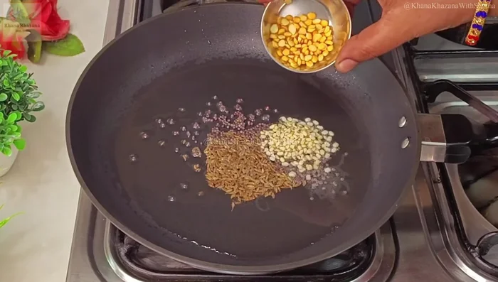Add cashew nuts, curry leaves, and green chili to the tempering. Fry briefly.