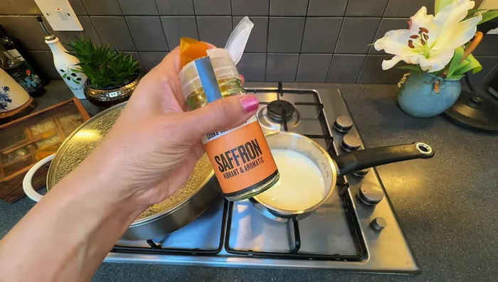 Gently warm milk; add saffron and cardamoms, let infuse.