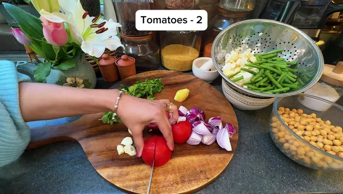 Blend red onions, tomatoes, ginger, garlic, coriander, and chili with a splash of water into a paste.