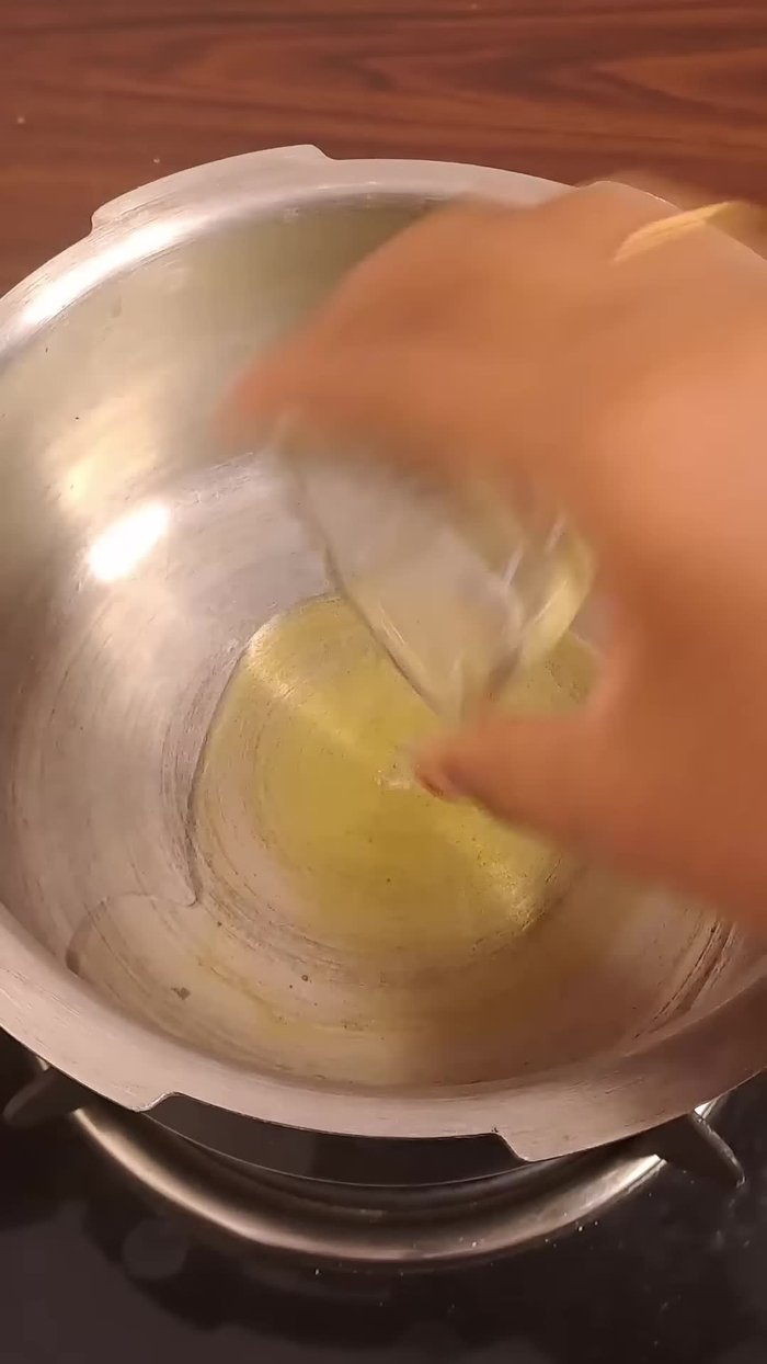 Add one sliced onion, two green chilies, and a teaspoon of ginger-garlic paste and sauté until the raw smell disappears.