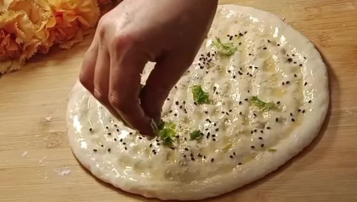 Add seeds and coriander: Sprinkle with nigella seeds, sesame seeds, and a little fresh coriander (170.8).