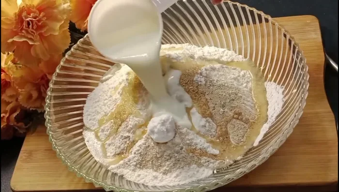 Prepare the dough: In a large bowl, combine flour, sugar, salt, yeast, curd, and oil. Gradually add water, mixing until a soft, smooth dough forms. Knead well for several minutes (21.279).