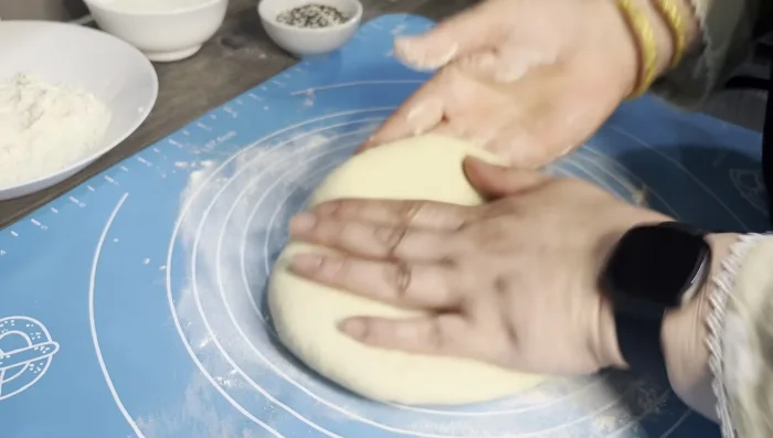 Lightly roll out the filled dough to flatten slightly. Using a wooden spoon, create indentations on the surface.