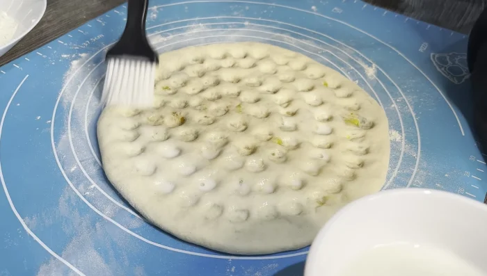Brush the naan with milk and sprinkle generously with sesame seeds and fresh coriander.