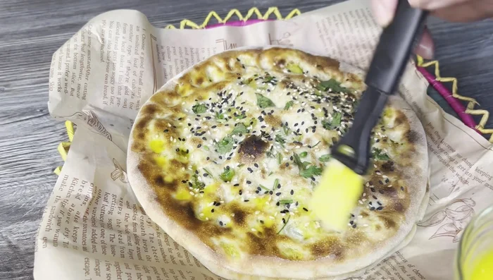 Brush the cooked naan with melted butter.