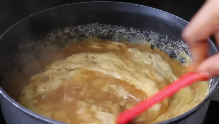 Continue mixing until the halwa reaches a stiff consistency.