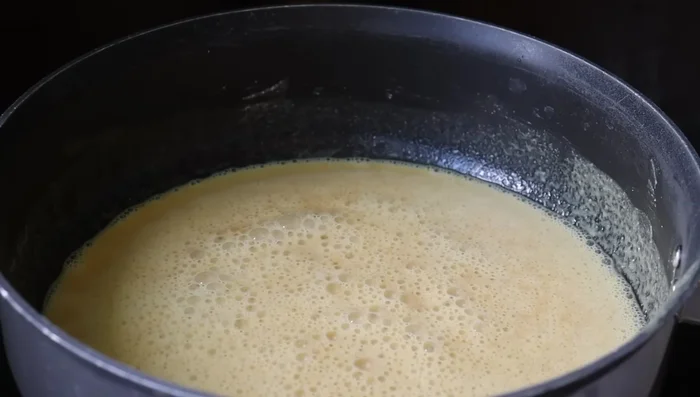 Filter the jaggery solution and add it to the fried wheat flour. Mix well immediately to prevent lumps. Keep the stove on medium flame.