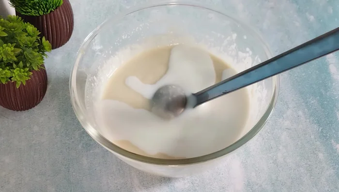 After resting, add any remaining milk and mix well again for 4-5 minutes. The batter should have a ribbon-like consistency.