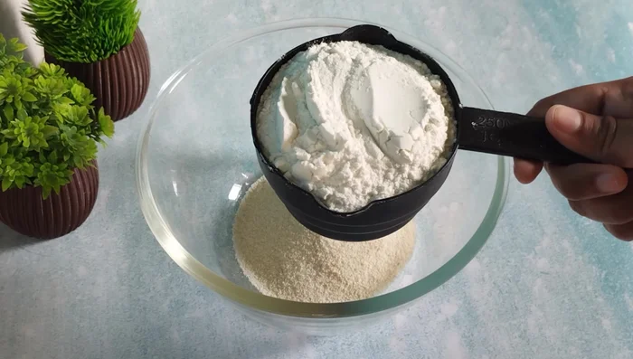 In a vessel, mix together semolina, flour, and sugar (or jaggery) thoroughly.